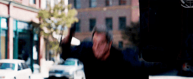 a blurry picture of a man standing in front of a building with his hands in the air