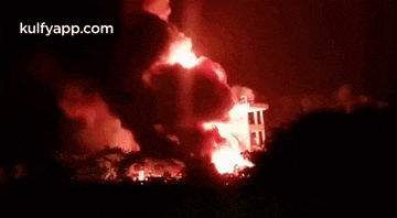 a large fire is burning in the sky over a building .