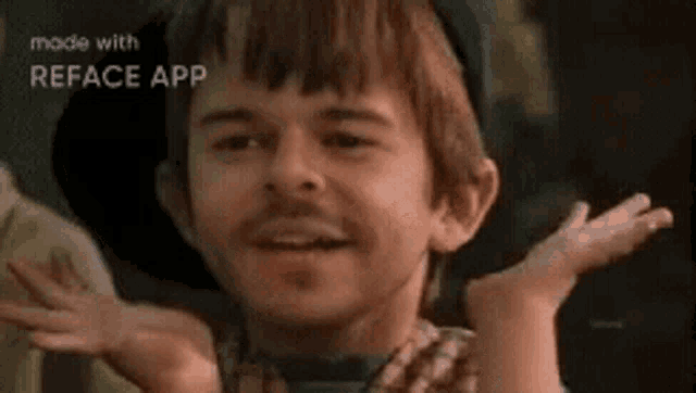 a young boy with a hat on is making a funny face with his hands outstretched .