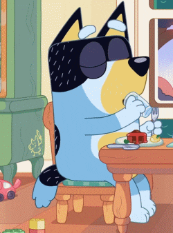 a cartoon dog wearing sunglasses sits at a table with a plate of food