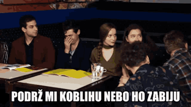 a group of people sitting around a table with the words podrz mi koblihu nebo ho zabiju on the bottom