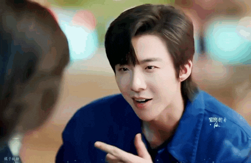 a young man in a blue jacket is talking to another man .