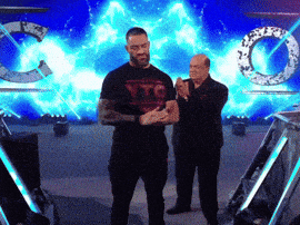 two men are standing in front of a blue background with the letters tc on it