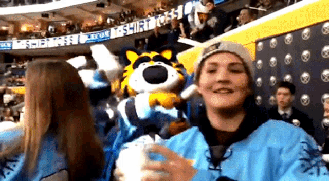 tony the tiger mascot is being held by a man in a blue jacket