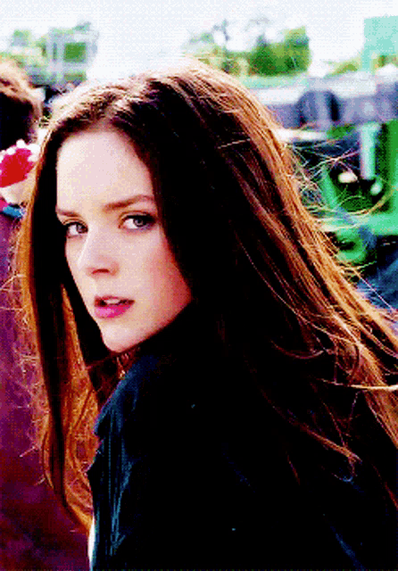 a close up of a woman 's face with long brown hair