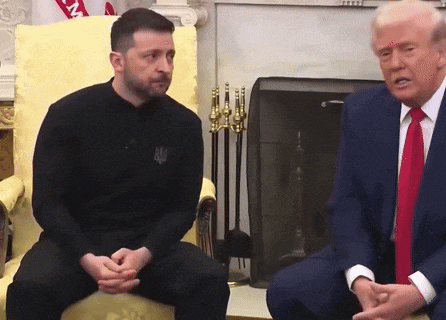 a man in a black shirt with the word ukraine on it sits next to a man in a suit
