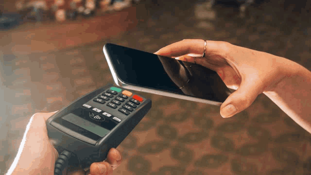 a person is using a phone to pay with a credit card machine
