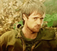 a man with a beard is wearing a green jacket and a green shirt .