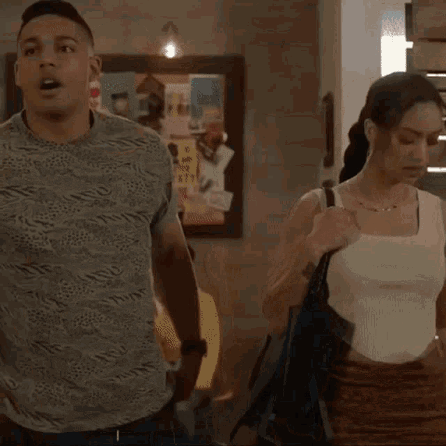 a man and woman are standing next to each other in a room .
