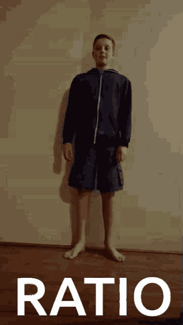 a boy is standing in front of a wall and the word ratio is on the bottom