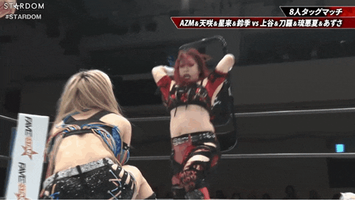 a female wrestler is holding a gun in a ring with a stardom logo on the bottom