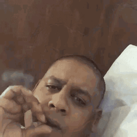 a man laying on a bed with a napkin in his mouth .
