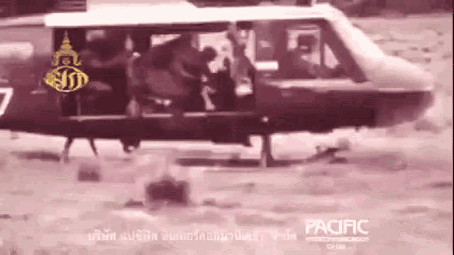 a helicopter with the number 7 on the side is flying over a body of water