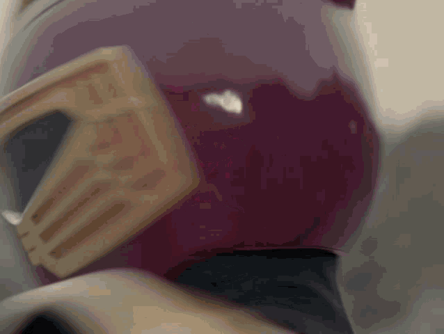a close up of a person wearing a purple helmet with a gold emblem