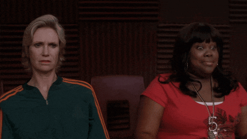 a woman wearing a red shirt with the number 5 on it sits next to another woman