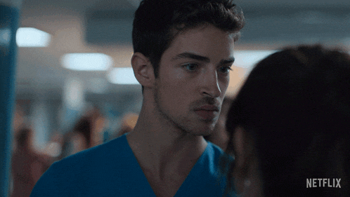 a man in a blue scrub is looking at a woman with netflix written on the bottom