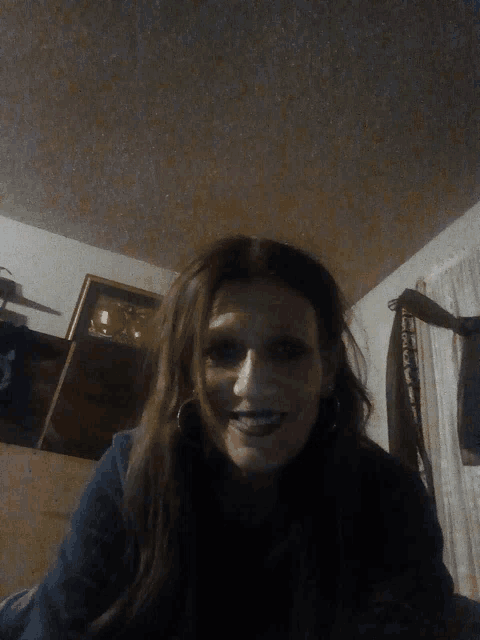 a woman in a dark room with a clock on the wall