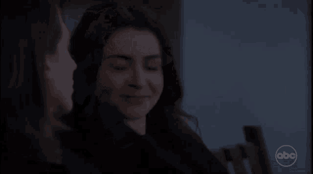 two women are sitting next to each other in a dark room with a abc logo in the corner