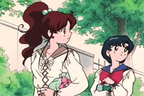 a couple of anime girls are standing next to each other in a park .