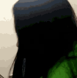 a close up of a person 's face with a green jacket on