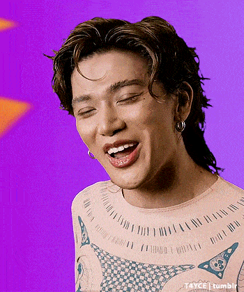 a close up of a person 's face with their mouth open and a purple background .