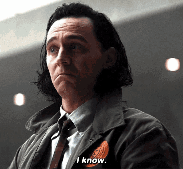 a man in a suit and tie is making a sad face and says `` i know '' .