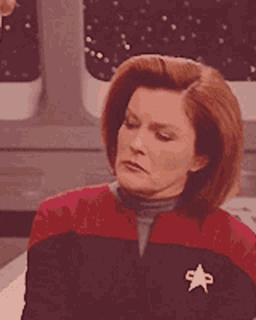 a woman wearing a red and black jacket with a white star on her collar