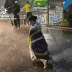 a woman in a striped dress is kneeling down in the rain .