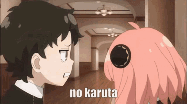 a boy and a girl are standing next to each other in a hallway and the girl is saying no karuta .