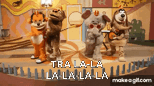 a group of stuffed animals are standing next to each other on a stage and singing .