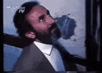 a man with a beard is on a tv screen that says ' hyperlase tv ' on it