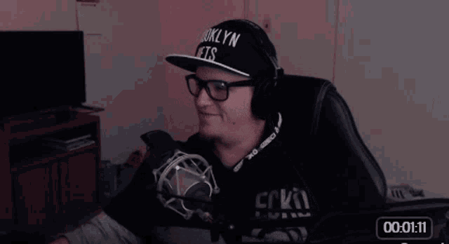 a man wearing headphones and a hat that says brooklyn on it