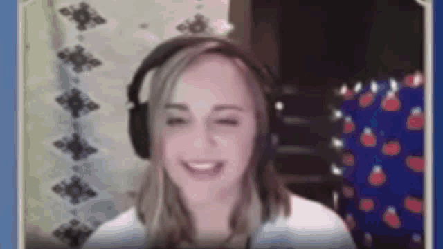 a woman wearing headphones is smiling and making a face .