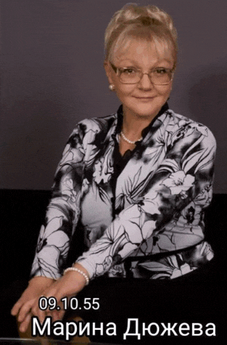 a woman wearing glasses and a pearl necklace has the date 09.10.95 on her shirt