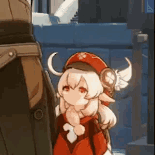 a little girl with wings on her head is standing next to a man in a red hat .