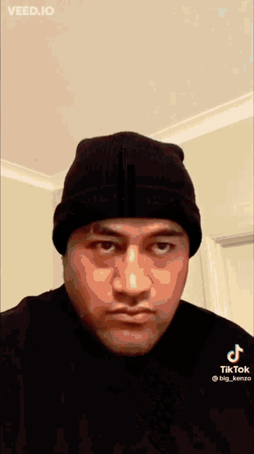 a man wearing a black beanie and a black shirt with tiktok written on the bottom right