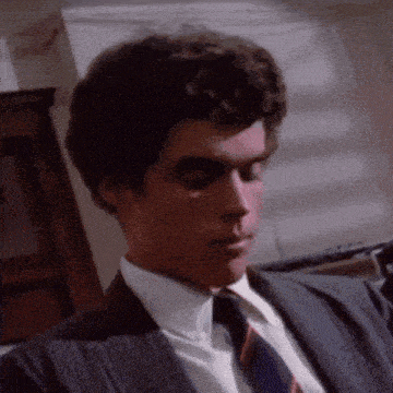 a man in a suit and tie is looking at something