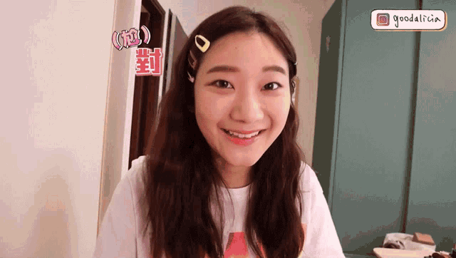 a girl with braces on her teeth is smiling in front of a sign that says goodalice