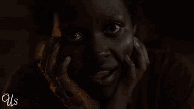 a close up of a woman 's face with us written on the bottom right