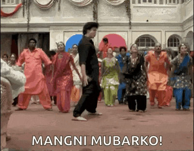 a group of people are dancing in a room with the words mangni mubarko on the bottom .