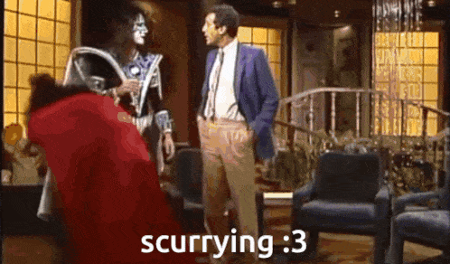 a man in a suit and tie is talking to a man in a costume with the words scurrying : 3 on the bottom