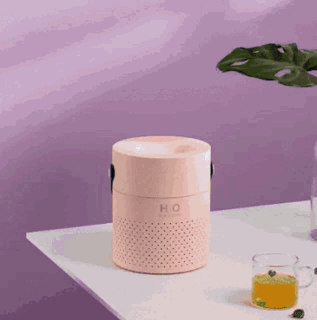 a pink humidifier is sitting on top of a white table .