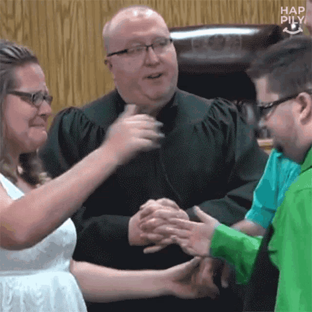 a man in a judge 's robe is shaking hands with a man in a green shirt