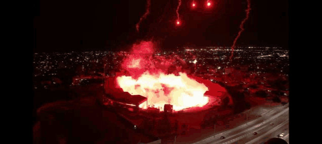 an aerial view of a fireworks display over a stadium at night