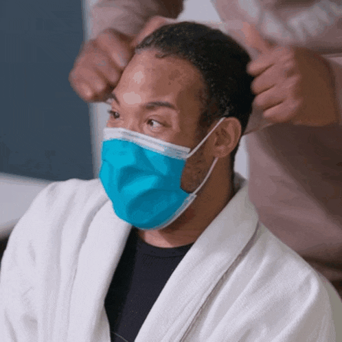 a man wearing a bathrobe and a blue mask