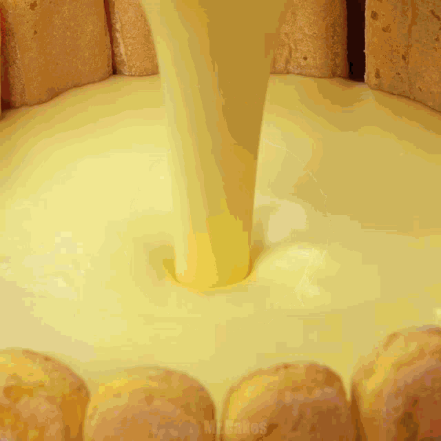 a yellow liquid is being poured into a cake with mr.cakes written on the bottom