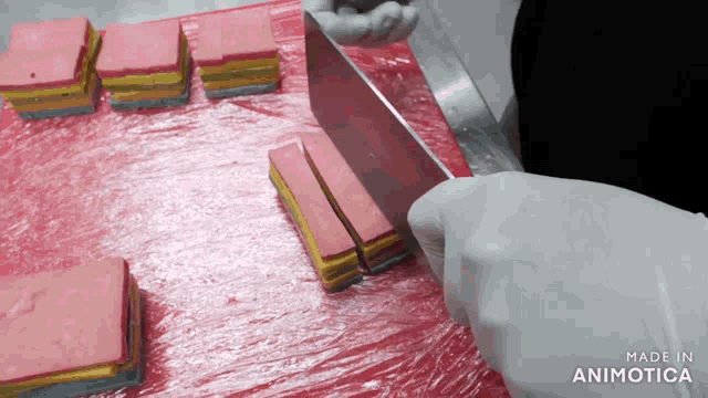 a person is cutting candy on a cutting board with the words made in animotica visible