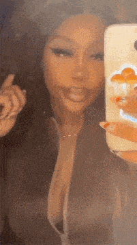 a woman is taking a selfie in front of a mirror with a mushroom case on her phone .