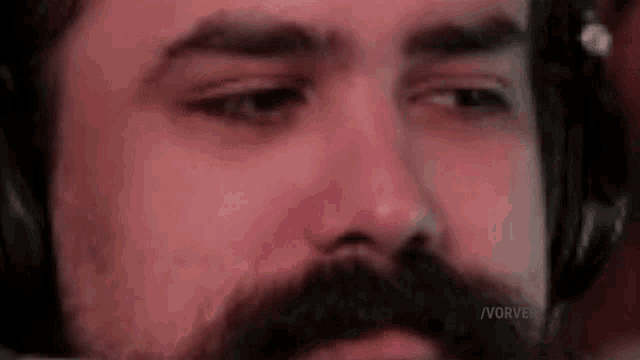 a close up of a man 's face with a beard and headphones .