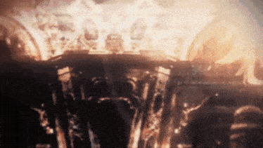 a blurred image of a burning building with a lot of flames coming out of it